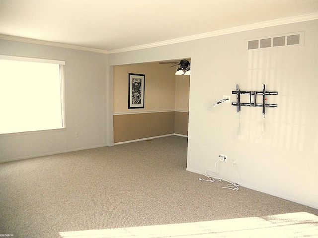 carpeted empty room featuring visible vents and crown molding