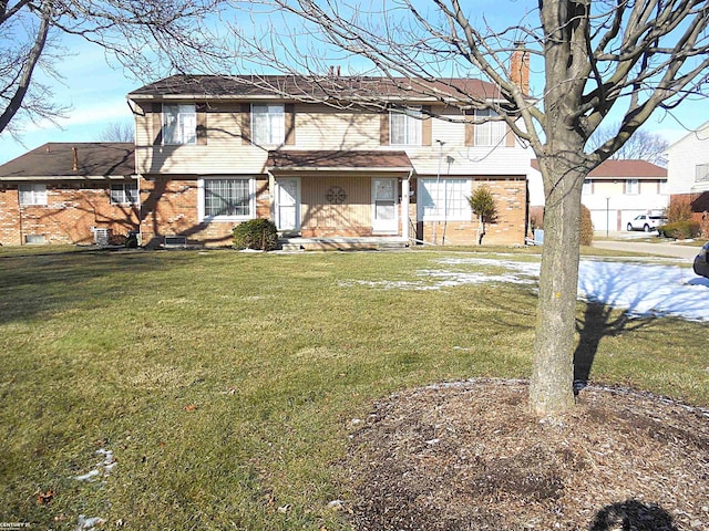 view of front of home with brick siding and a front yard