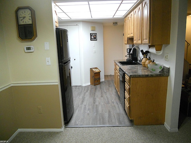 kitchen featuring fridge, baseboards, a sink, and dishwasher