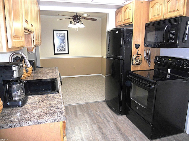 kitchen with baseboards, ceiling fan, light brown cabinetry, light wood-type flooring, and black appliances