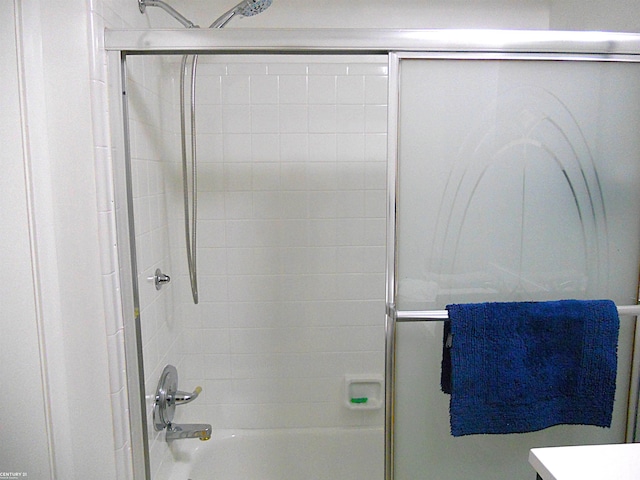 bathroom featuring bath / shower combo with glass door and vanity