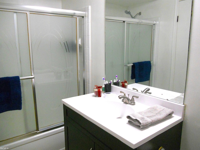 bathroom featuring shower / bath combination with glass door and vanity