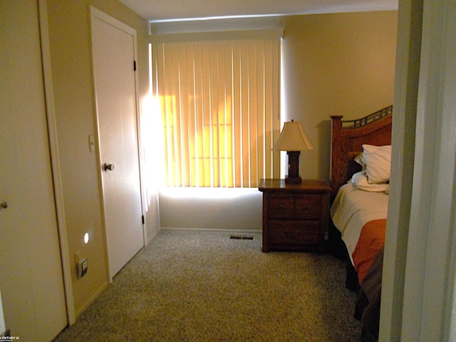 carpeted bedroom featuring visible vents