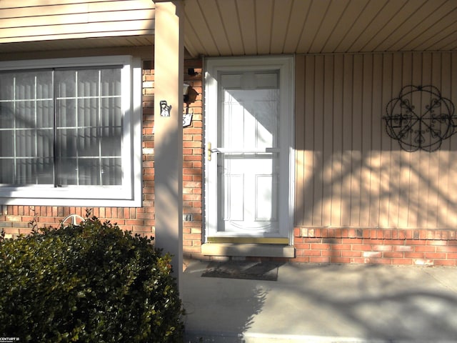 doorway to property featuring brick siding