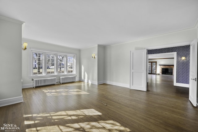 unfurnished living room with dark wood-style flooring, baseboards, and radiator heating unit