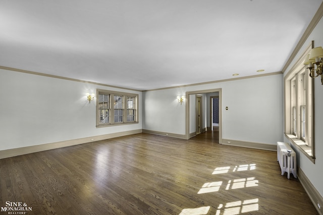 empty room featuring baseboards, ornamental molding, wood finished floors, and radiator