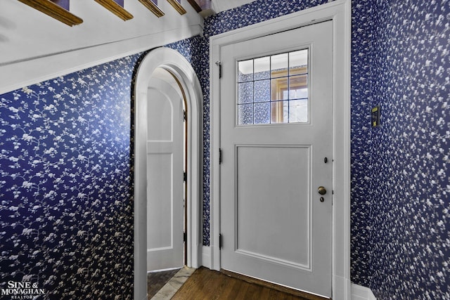 interior space featuring wood finished floors and wallpapered walls