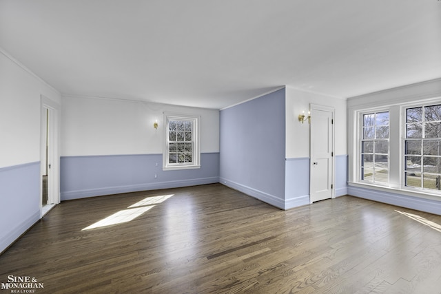 unfurnished room featuring ornamental molding, baseboards, and wood finished floors