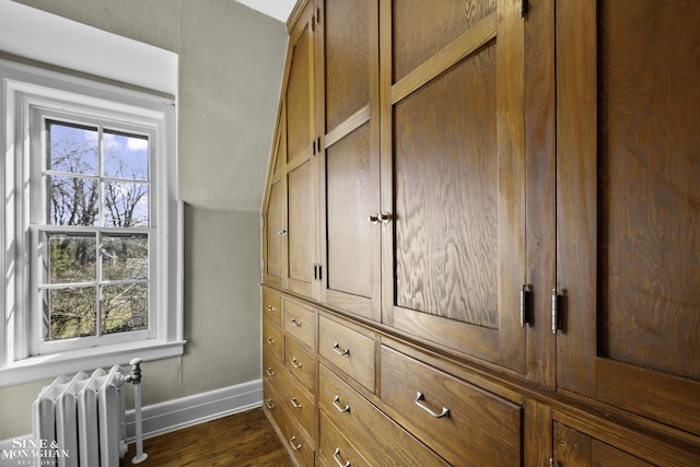 room details with radiator heating unit, wood finished floors, and baseboards