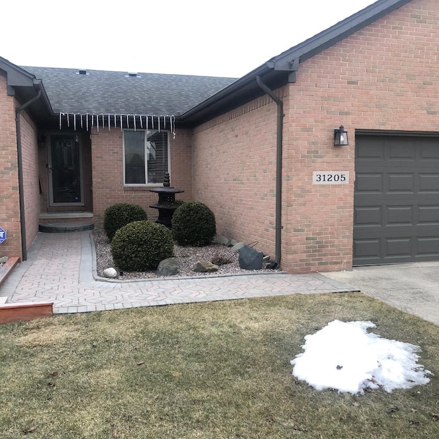 view of side of property with a garage, brick siding, and a shingled roof