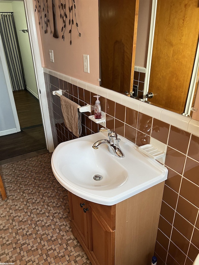 bathroom with a wainscoted wall, vanity, and tile walls