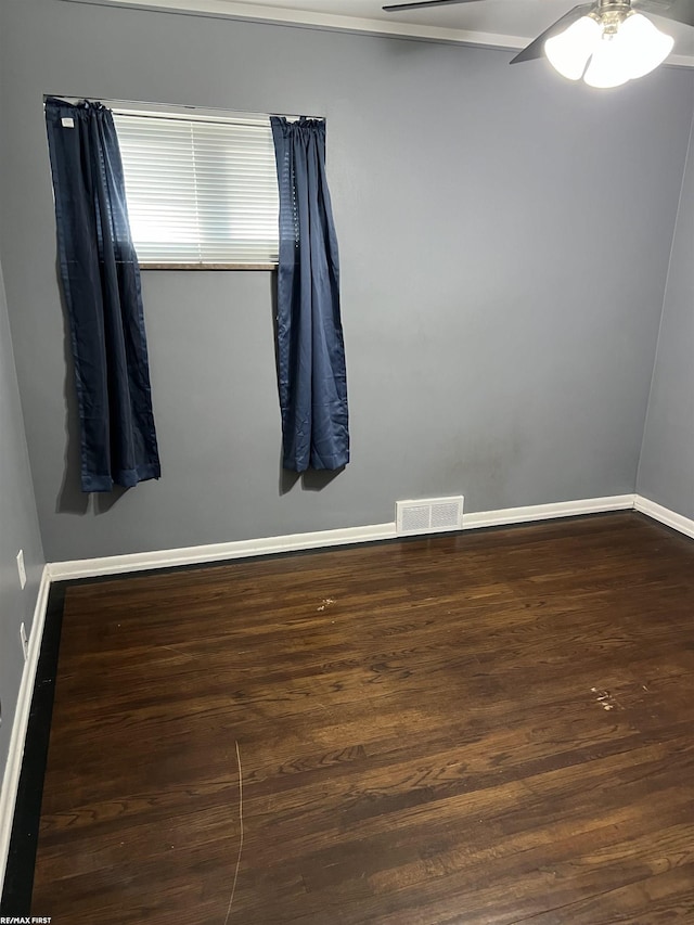 empty room with a ceiling fan, baseboards, visible vents, and wood finished floors