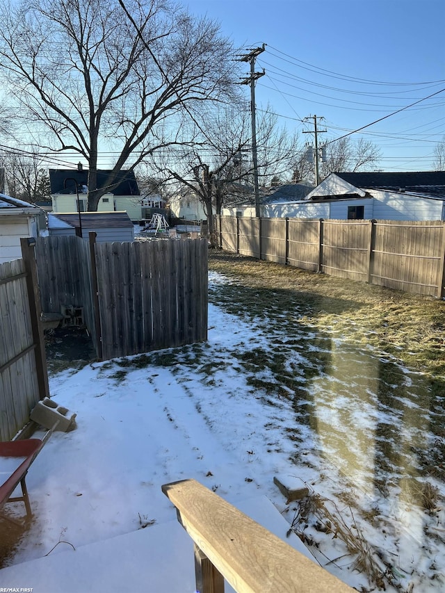 snowy yard featuring fence