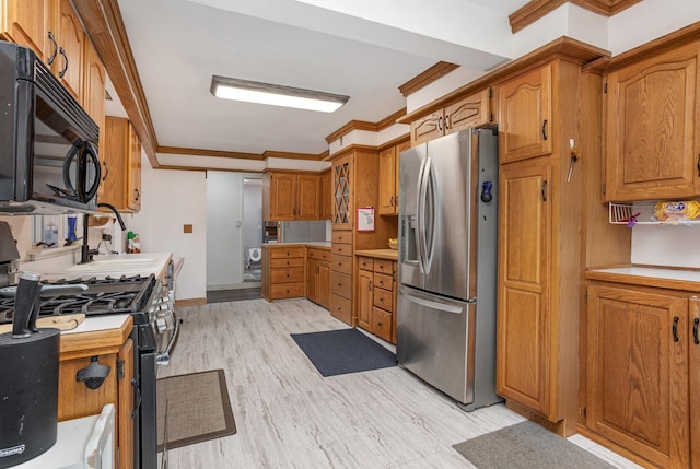 kitchen with black microwave, range with gas stovetop, brown cabinets, and stainless steel fridge with ice dispenser