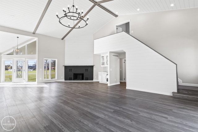 unfurnished living room with a fireplace with raised hearth, dark wood-style flooring, beam ceiling, and baseboards