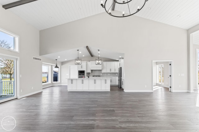 unfurnished living room with beam ceiling, visible vents, baseboards, and an inviting chandelier