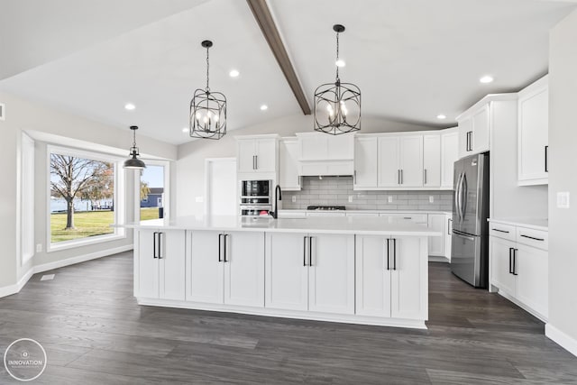 kitchen with appliances with stainless steel finishes, light countertops, lofted ceiling with beams, and white cabinetry