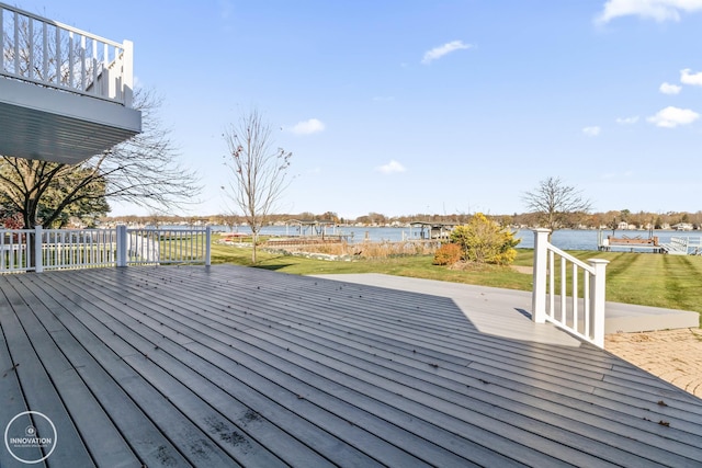 wooden deck featuring a water view and a lawn