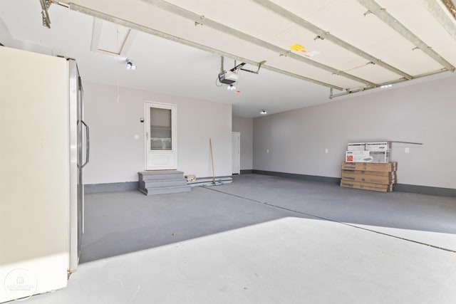 garage with baseboards, freestanding refrigerator, and a garage door opener