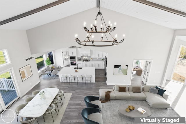 1600 N Channel Dr, Harsens Island, MI 48028 - living area with a chandelier, high vaulted ceiling, healthy amount of natural light, wood finished floors, and beamed ceiling