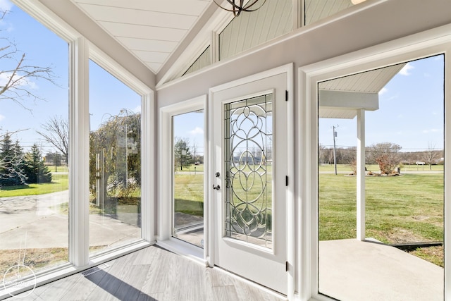 doorway with vaulted ceiling and wood finished floors