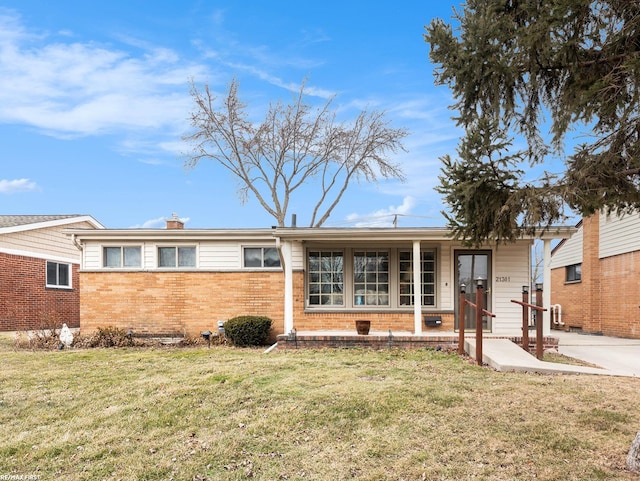 ranch-style house featuring brick siding, a chimney, and a front yard