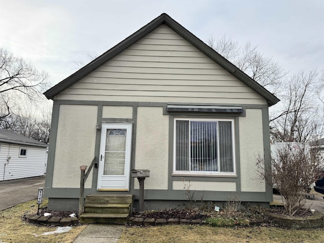 view of front facade featuring entry steps and stucco siding