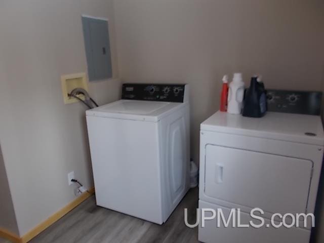 washroom with washer and dryer, laundry area, electric panel, and light wood-style flooring