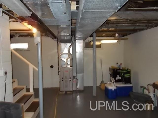 unfinished basement with heating unit and stairway