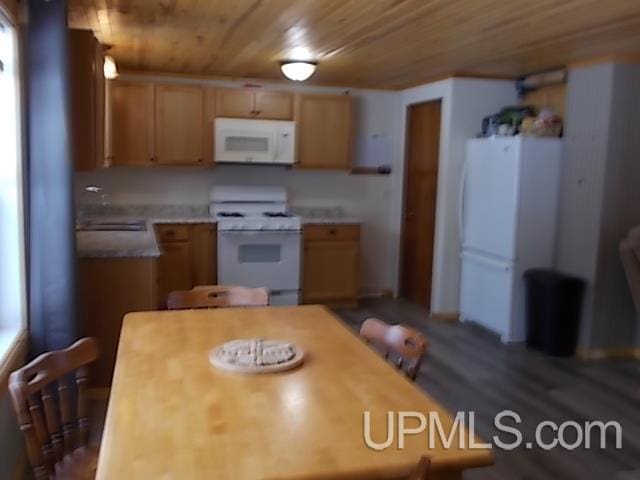 kitchen with light countertops, white appliances, wooden ceiling, and a sink