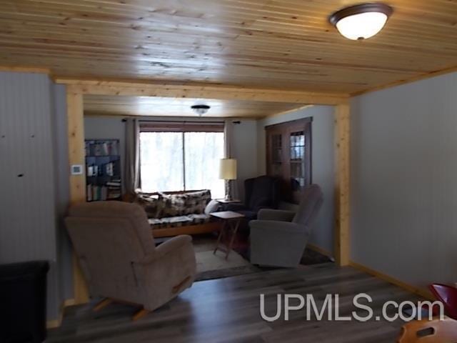 living area featuring wooden ceiling, wood finished floors, and baseboards