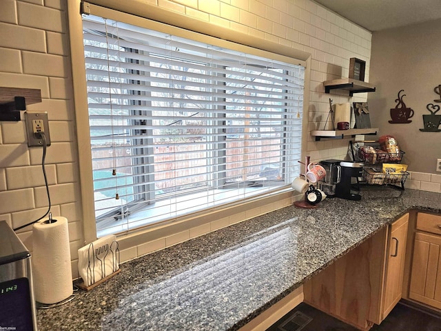 kitchen featuring open shelves, tasteful backsplash, visible vents, brown cabinetry, and dark stone countertops