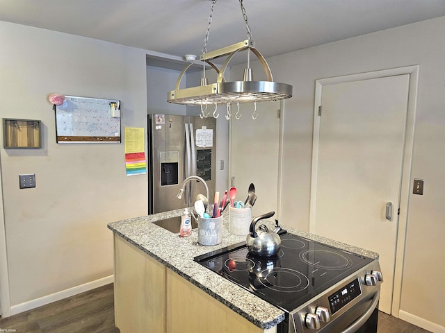 kitchen featuring stainless steel appliances, dark wood-style flooring, a sink, baseboards, and light stone countertops