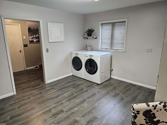 laundry room with laundry area, dark wood-style flooring, washing machine and clothes dryer, and baseboards