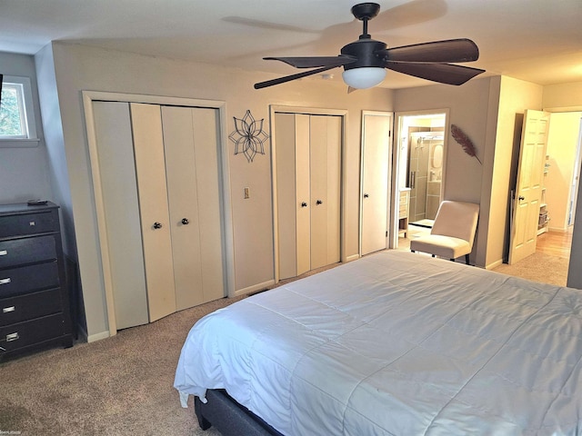 bedroom with light carpet, ceiling fan, baseboards, and multiple closets