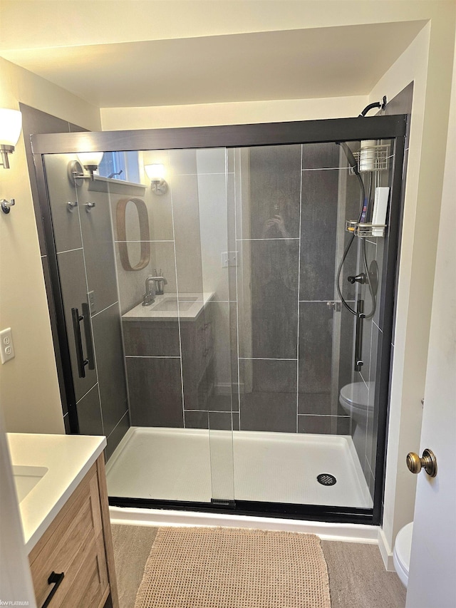 full bathroom featuring a shower stall, vanity, and toilet