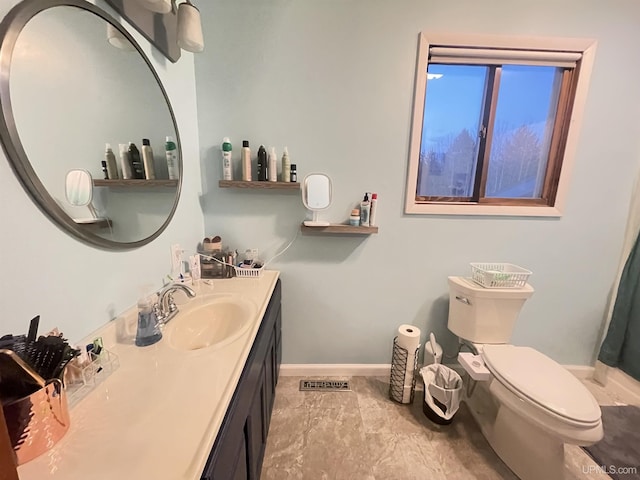 bathroom featuring visible vents, vanity, toilet, and baseboards