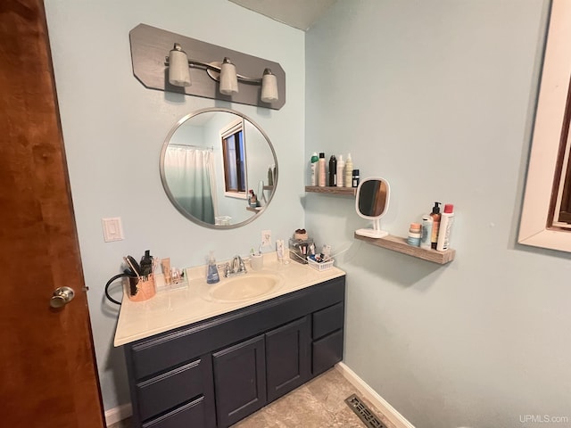 bathroom featuring visible vents, baseboards, and vanity