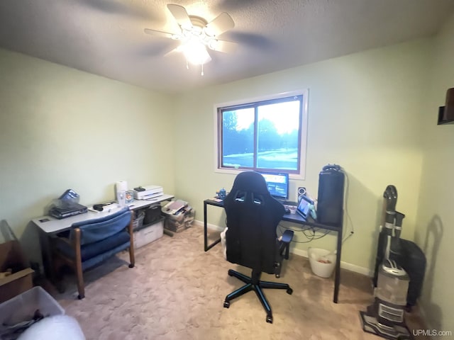 carpeted home office with a ceiling fan and baseboards