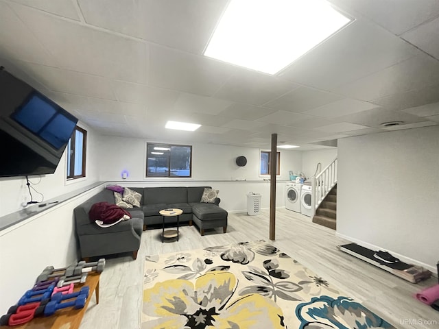 interior space with a paneled ceiling, wood finished floors, washer and dryer, baseboards, and stairs