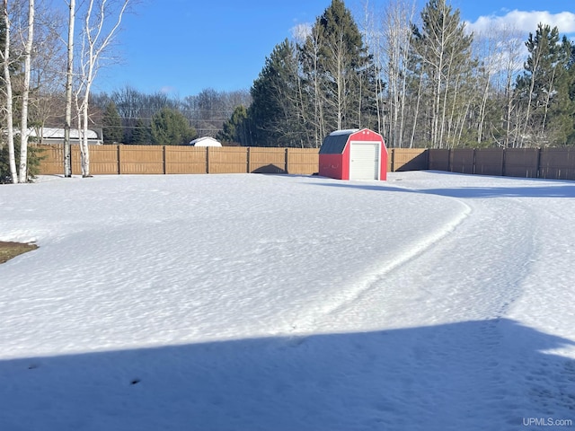 view of yard featuring a storage shed, an outdoor structure, a fenced backyard, and a garage