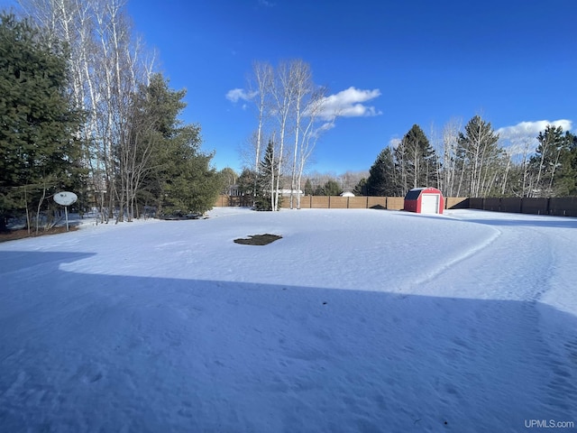 view of yard with a shed, fence, and an outbuilding