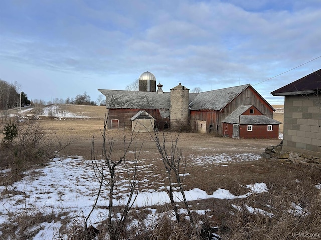 snowy yard featuring an outdoor structure and a barn