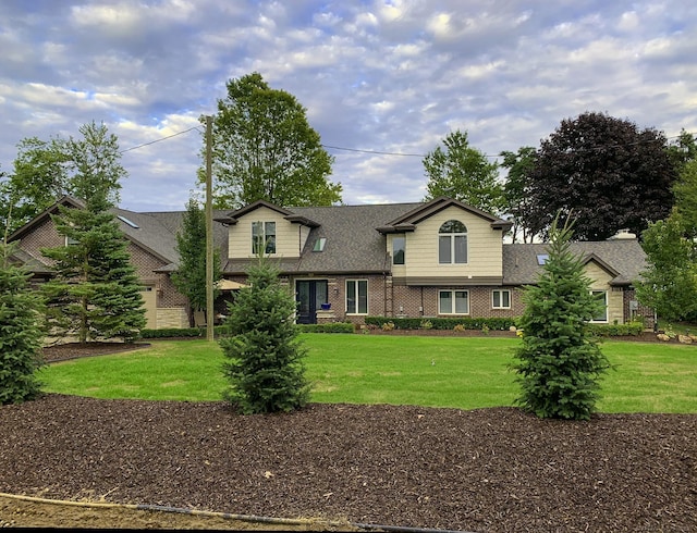 traditional-style house with brick siding and a front yard