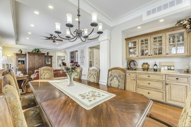 dining space featuring a tray ceiling, crown molding, light wood finished floors, recessed lighting, and visible vents