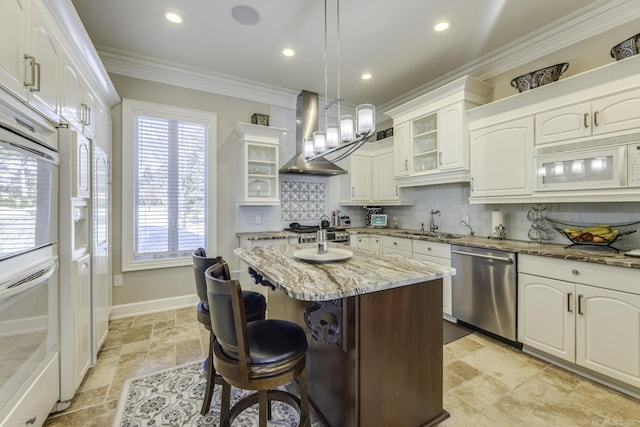 kitchen featuring decorative backsplash, ornamental molding, a sink, wall chimney range hood, and white appliances