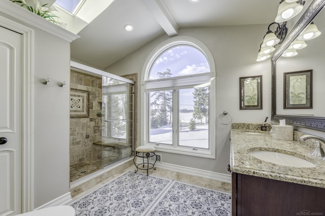 bathroom with double vanity, vaulted ceiling with skylight, a sink, and tiled shower