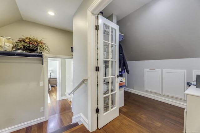 interior space with lofted ceiling, baseboards, and hardwood / wood-style flooring