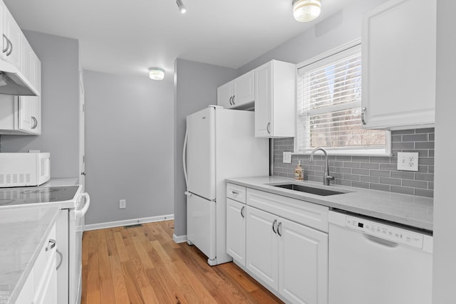 kitchen featuring white cabinets, white appliances, backsplash, and a sink