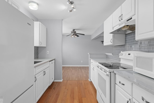 kitchen featuring white appliances, under cabinet range hood, white cabinetry, and light countertops